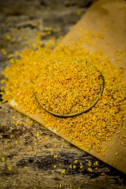 Ahşap yüzey üzerinde bir kasede ezilmiş Çemen otu tohumu