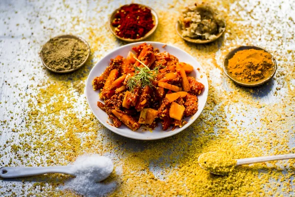 Kırmızı biber tozu, zencefil sarımsak yapıştırın ahşap arka plan üzerinde zerdeçal tozu ile geleneksel havuç turşusu