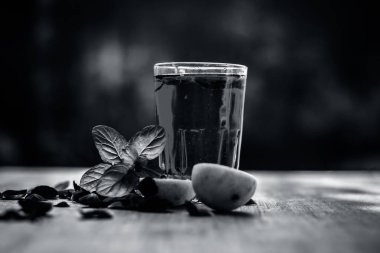 Ahşap yüzeyde popüler Hint içki dilimlenmiş limon, gül yaprakları ve nane yaprakları.