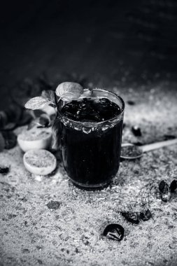 Karışık meyve suyu malzemelerle gibi limon, nane bir şeffaf cam ahşap yüzeyde bırakır.