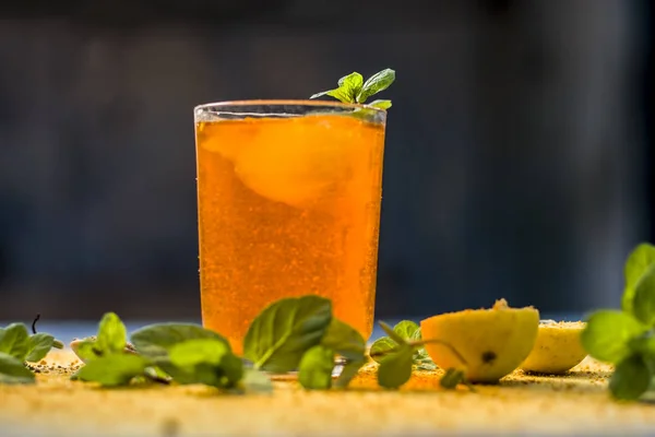 stock image orange sharbat with black pepper powder, mint leaves and a pinch of salt on wooden surface