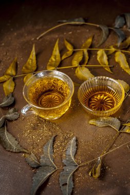 Neem çay yaprakları üzerinde ahşap masa ile iki bardak