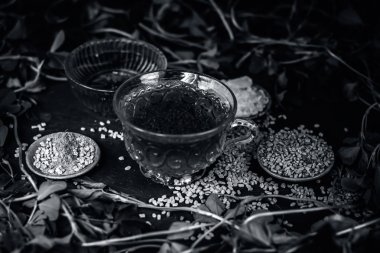 Bal ile Çemen otu çayı, Çemen otu yaprakları ve bir ahşap yüzeye karanlık gotik renklerde tohumlar 