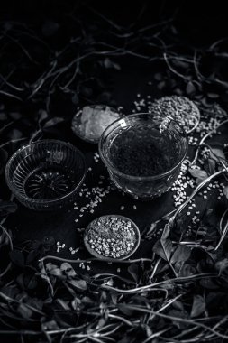 Bal ile Çemen otu çayı, Çemen otu yaprakları ve bir ahşap yüzeye karanlık gotik renklerde tohumlar 