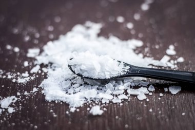 Ahşap arka plan üzerinde küçük kaşık kafur kristallerinin yakın çekim