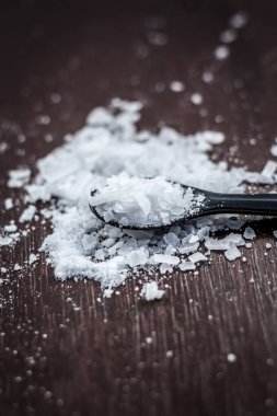 Ahşap arka plan üzerinde küçük kaşık kafur kristallerinin yakın çekim