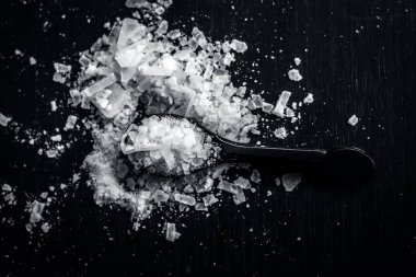 Yukarıdan küçük kaşık kafur toz siyah arka plan üzerine