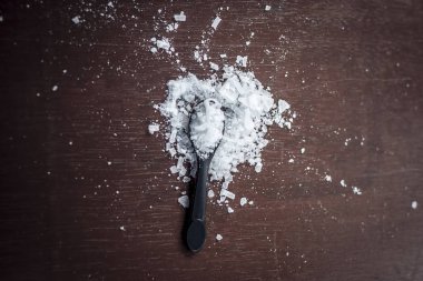Ahşap arka plan üzerinde küçük kaşık kafur toz üstten görünüm