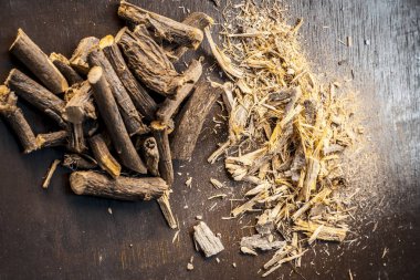 Koyu ahşap masa üzerinde bir Ayurveda meyan köküne üstten görünüm