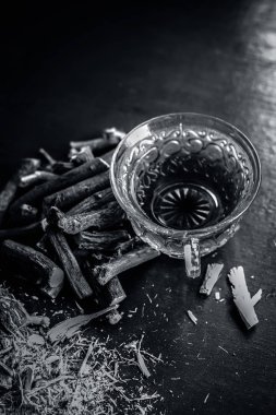 Meyan kökü kökleri üzerinde ahşap arka plan ile çay kapatır