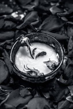 Süt krem gül yaprakları üzerinde yüz için kase
