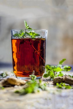 Masada bitkisel içkiyle şeffaf cam