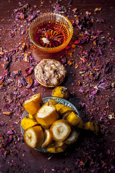 Face mask from banana and honey with flower petals on table