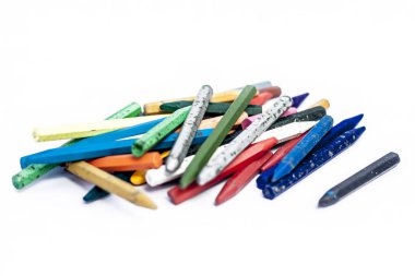 Beyaz arka plan üzerinde renkli mum boya kalemi yığını