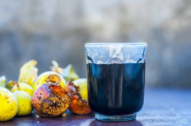 İncir ağacı ve ahşap masa üzerinde bitkisel İçecek taze meyvelerin yakın çekim