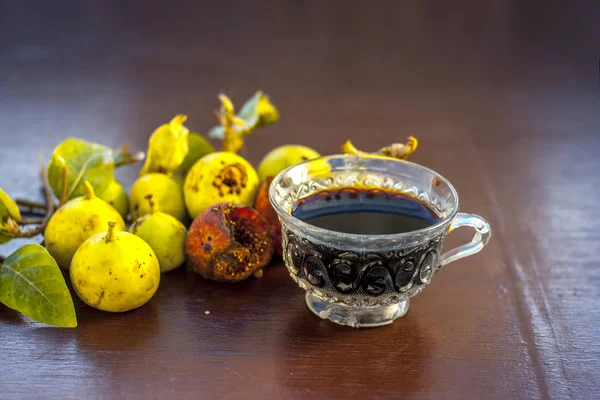 İncir ağacı ve ahşap masa üzerinde bitkisel İçecek taze meyvelerin yakın çekim