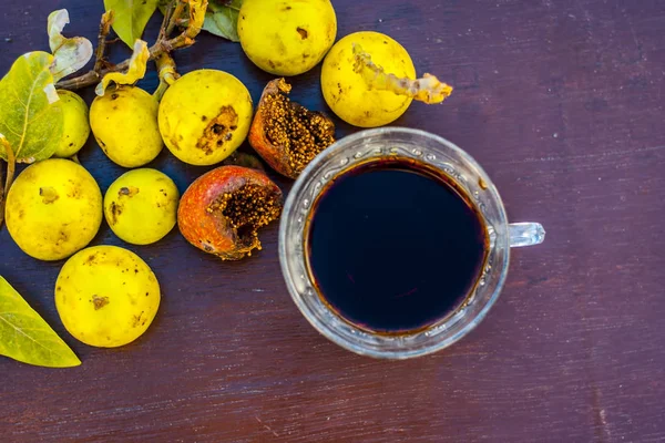 İncir ağacı ve ahşap masa üzerinde bitkisel İçecek taze meyvelerin yakın çekim