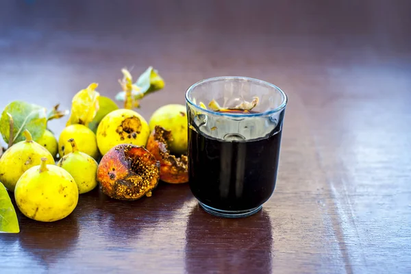 İncir ağacı ve ahşap masa üzerinde bitkisel İçecek taze meyvelerin yakın çekim