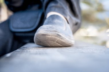 Siyah ayakkabılar ve siyah kot giyen insan bacakları yakın çekim.