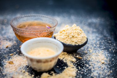 Yulaf yüz paketi Yani gül suyu, yulaf, gram un ve bal kaplıcada temiz ve pürüzsüz cilt için kullanılan ahşap yüzeye yakın çekim.