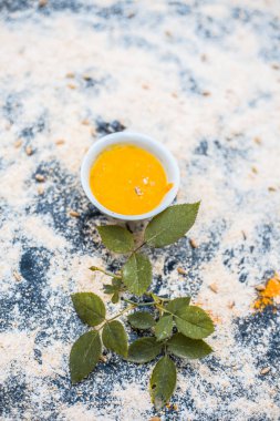 Gül suyu yüz paketi veya doğal parlak ve parlak ten Yani gül suyu, yulaf ve zerdeçal bazı gül yaprakları ve yaprakları ile ahşap yüzeyde için yüz maskesi yakın çekim.