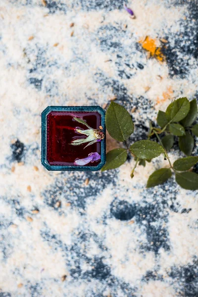 Close up of Rose water face pack or facial mask for natural glowing and bright skin i.e. Rose water,oats and turmeric on wooden surface with some rose leaves and petals.