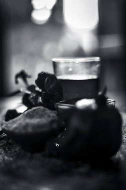 Nar nar tohum suyu ve bazı gül yaprakları ve yaprakları ile ahşap yüzeyi cilt yeniden canlandırmak için bazı zemin veya toz yulaf ile bitkisel ve organik yüz paketi. siyah ve beyaz