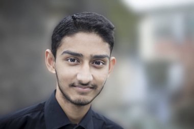 portre yakışıklı nazik adam veya iş adam siyah renkli gömlek giymiş, Posing ve elde bir şey, gurur olarak gülümseyen.