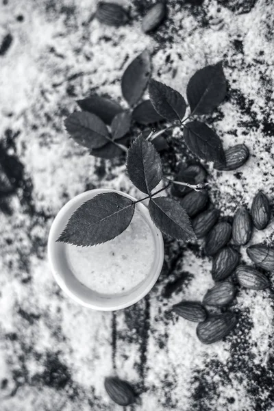 Close up of oats face pack or Avena sativa facial mask i.e  crushed or powdered almonds or badam,milk and grounded oats on wooden surface.This face pack is widely used in spa for de-tanning.