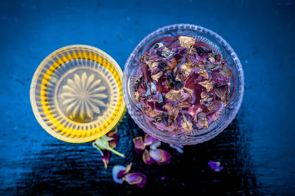 Close up of face pack of rice flour with honey and rose water on wooden surface in a glass container with rose water and rice flour used to clean acne and pimples.