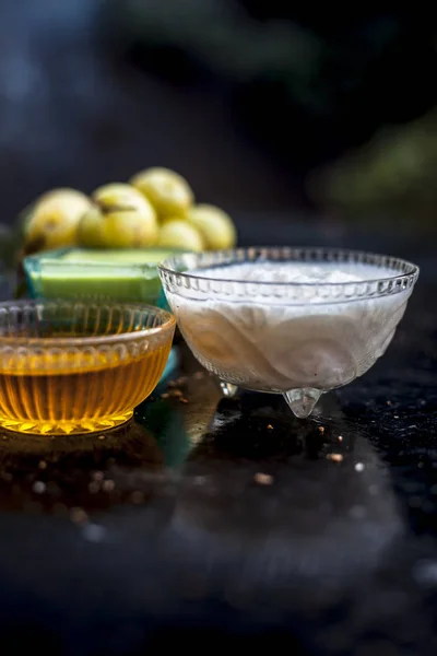 Herbal face pack of amla with yogurt and honey on wooden table