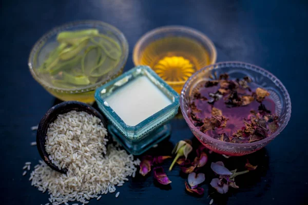 Close up of face pack of rice flour with honey and rose water on wooden surface in a glass container with rose water and rice flour used to clean acne and pimples.