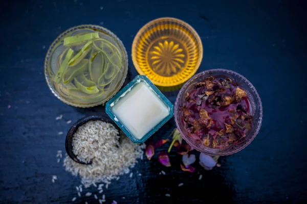 Close up of face pack of rice flour with honey and rose water on wooden surface in a glass container with rose water and rice flour used to clean acne and pimples.