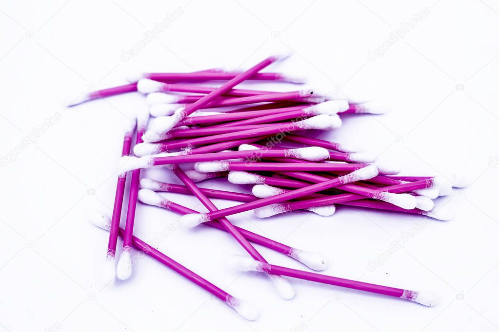 Pink colored cotton coated ear buds or Q-tips isolated on white.