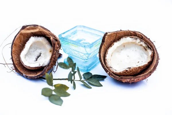 Close up of raw organic oil of Coconut with raw coconut isolated on white in a blue colored bowl.
