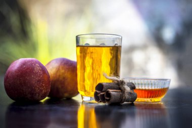 Yakın ahşap yüzey üzerinde elma suyu ile tüm malzemeyi yani elma suyu ve tarçın sopa bal ile.