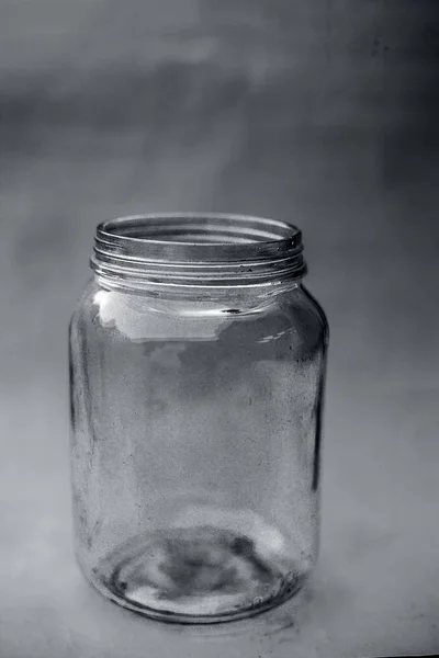 Close up of empty glass jar or storage jar or glass container isolated on pink surface.
