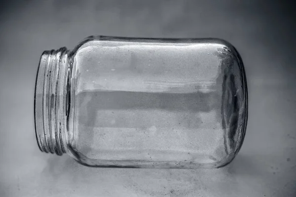 Close up of empty glass jar or storage jar or glass container isolated on pink surface.