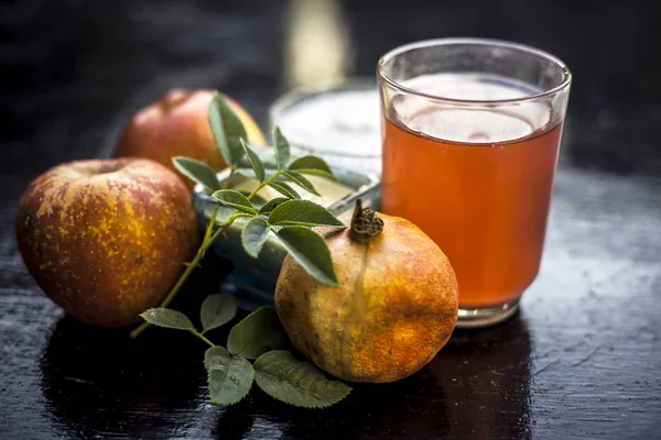 Instant grow therapy on wooden surface i.e. face pack of apple or pomegranate consisting of apple,curd or yogurt and pomegranate juice in a glass bowl,close up view.