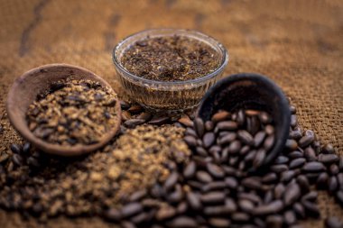 Ev çare ham muhallebi elma tohumları ile bir cam kase su ve organik ham Hindistan cevizi yağı ile karışık kurutulmuş ve toz iyi kahverengi renkli yüzey Yani muhallebi elma tohumları üzerinde bit veya Joon tedavi etmek.