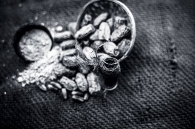 Kurutulmuş hurma veya sukhi khajoor veya Phoenix dactylifera ham kurutulmuş tarihleri ve toz ile kahverengi yüzeyüzerinde şeffaf bir cam şişe içinde kharek Uçucu yağ. Siyah beyaz