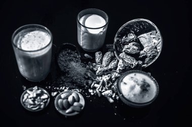 Ahşap yüzey üzerinde popüler Hint ve Asya Kış içecek yakın yani Kharek ka dudh veya kurutulmuş hurma süt süt, kurutulmuş hurma, kaju fıstığı, badem kuru meyve ve şeker oluşan. siyah beyaz
