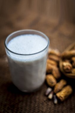 Kharek veya kurutulmuş hurma ile kahverengi renkli yüzeyüzerinde şeffaf bir cam çiğ süt ile siyah renkli kil kase kurutulmuş hurma bazı toz ile yakın.