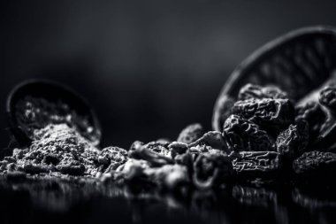 Ahşap yüzeyinde toz ile bir engel kurutulmuş hurma veya kharek veya sukhi khajoor yakın. siyah beyaz