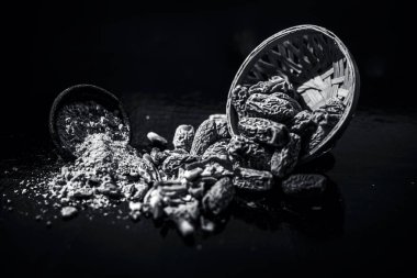 Ahşap yüzeyinde toz ile bir engel kurutulmuş hurma veya kharek veya sukhi khajoor yakın. siyah beyaz