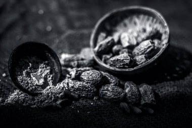 Siyah renkli kil kase içinde toz ile ham kurutulmuş organik kharek veya kurutulmuş hurma veya Phoenix dactylifera kapatın. siyah beyaz