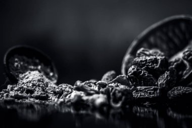 Ahşap yüzeyinde toz ile bir engel kurutulmuş hurma veya kharek veya sukhi khajoor yakın. siyah beyaz