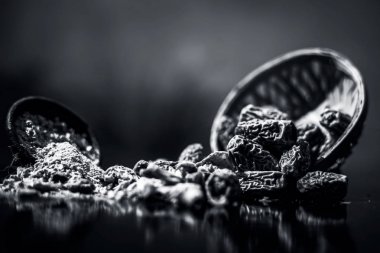 Ahşap yüzeyinde toz ile bir engel kurutulmuş hurma veya kharek veya sukhi khajoor yakın. siyah beyaz