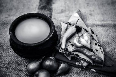 Bazı soğan ve biber, ayran ile inci darı roti veya chapati veya bajra veya bajri ki roti oluşan gunny çanta arka plan üzerinde yemek veya köylü öğle yemeği ya da tipik bir çiftçi kapatın. siyah beyaz