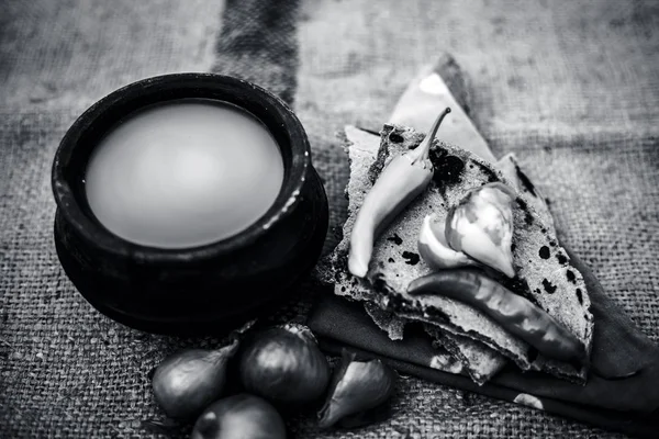 Bazı soğan ve biber, ayran ile inci darı roti veya chapati veya bajra veya bajri ki roti oluşan gunny çanta arka plan üzerinde yemek veya köylü öğle yemeği ya da tipik bir çiftçi kapatın. siyah beyaz